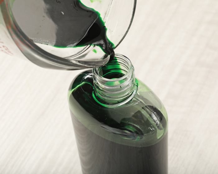 pouring lab color into bottle | bramble
                berry